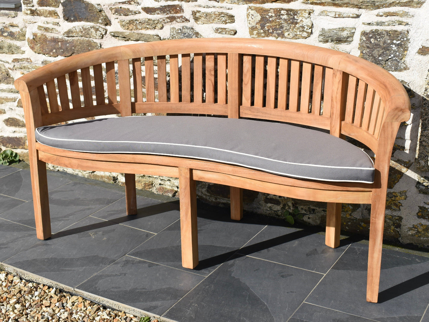 Grey curved banana bench outdoor cushion with contrast white piping and machine washable cover