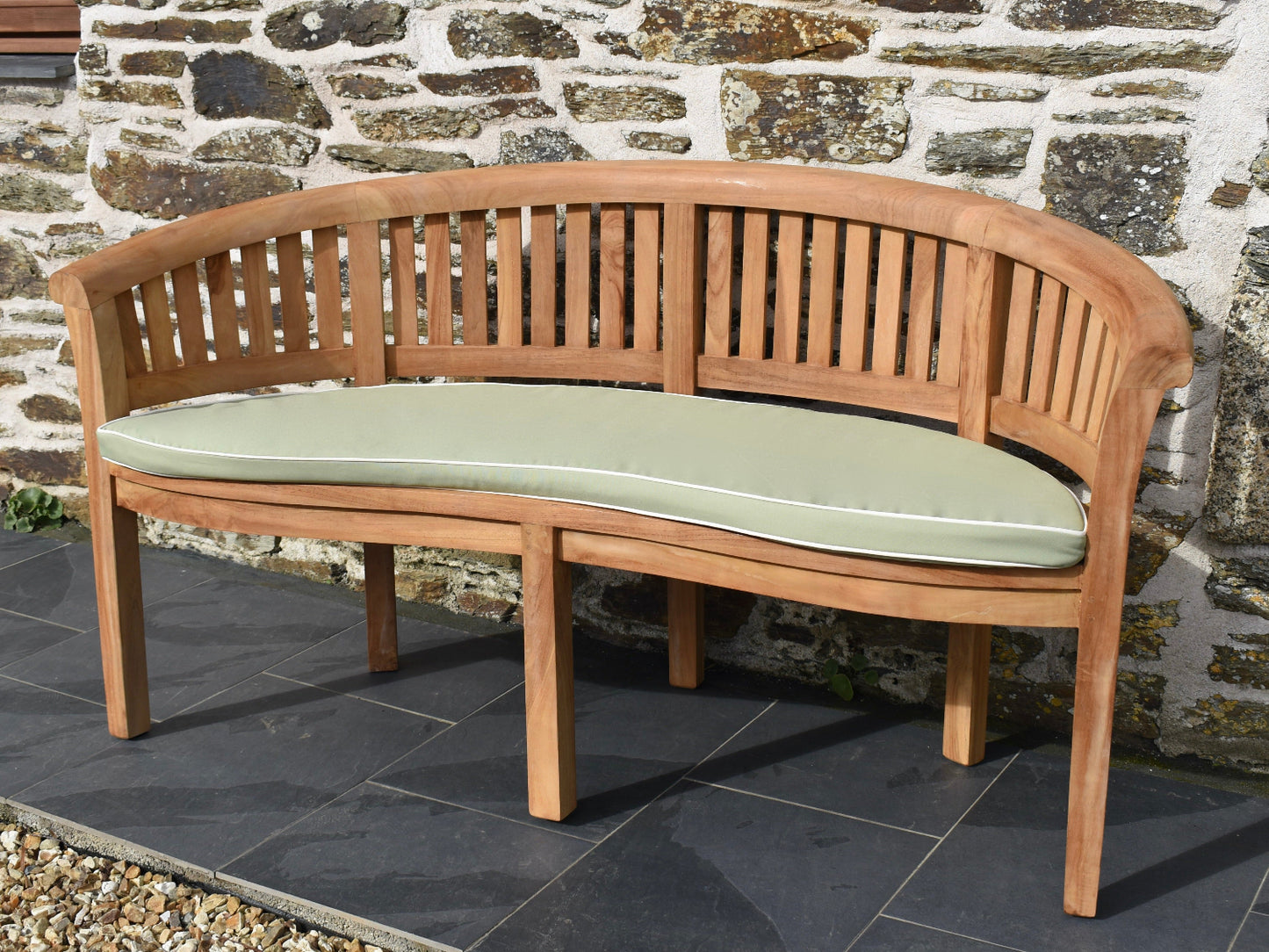 Light sage green curved banana bench outdoor cushion with contrast white piping and machine washable cover