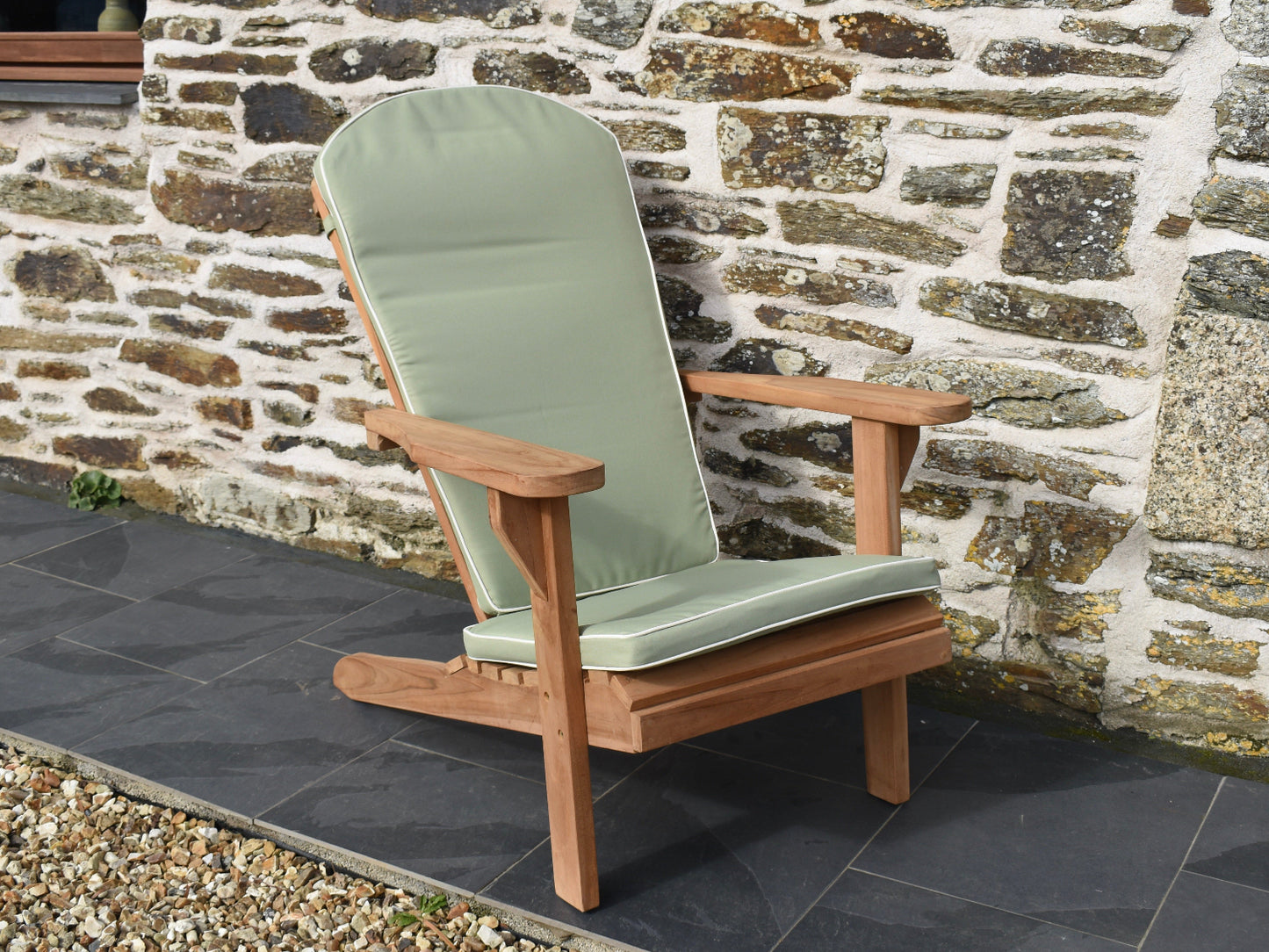 beautiful soft sage green garden cushion for an Adirondack style outdoor easy chair, featuring contrast withe piping and removable, machine washable cover.