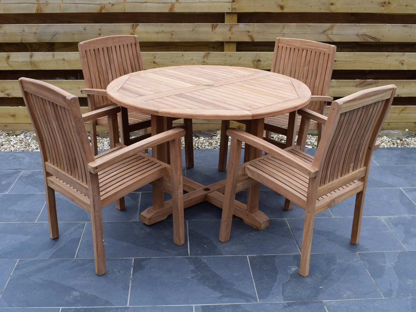 classic 120cm / 4ft round teak garden dining table with 4 teak Henley style stacking garden armchairs. 4 seater set ideally suited to both commercial and domestic use