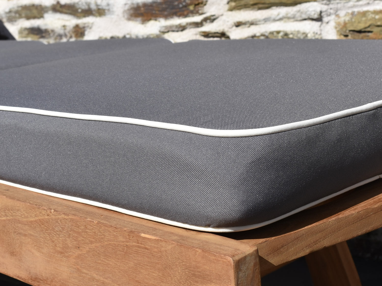 close up fabric detail of luxury dove grey sunlounger cushion with contrast white piping
