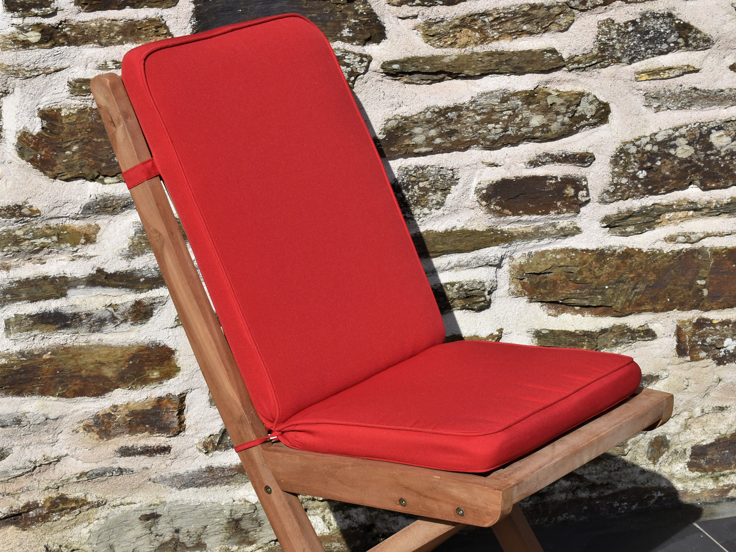 close-up bright red fabric garden folding pad/back chair cushions, finished with matching fabric piping, ties and back strap