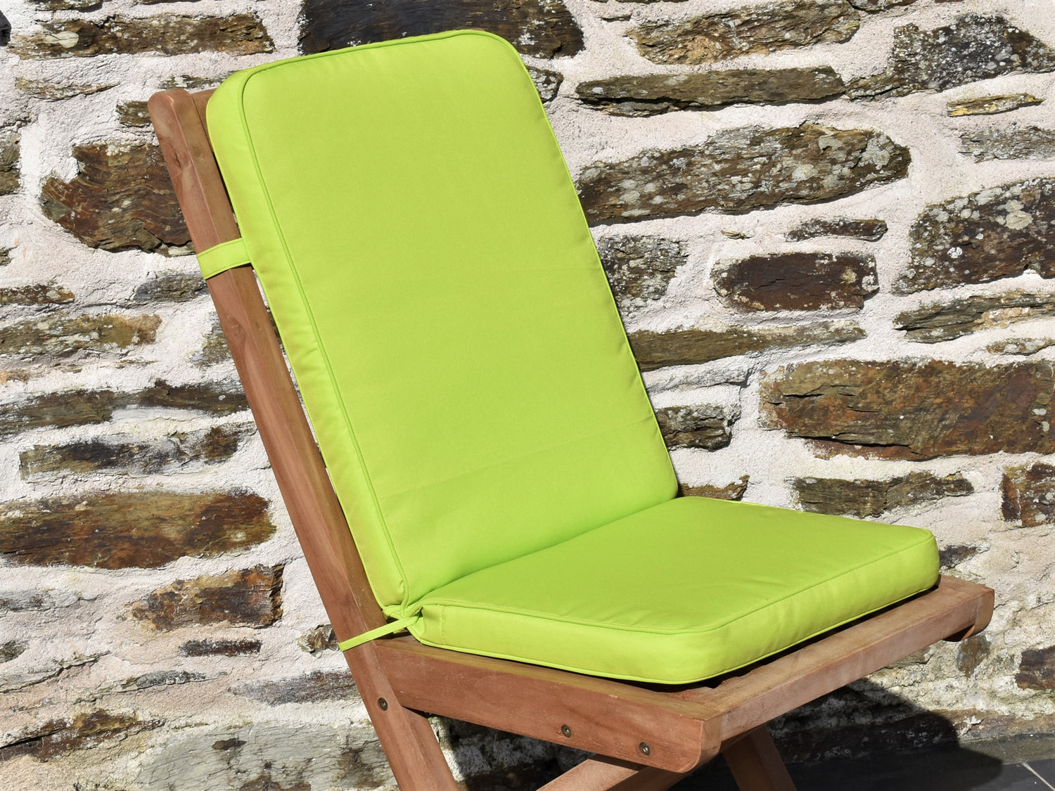 close-up of bright light green fabric folding pad/back garden cushion, finished with matching fabric piping, ties and back strap
