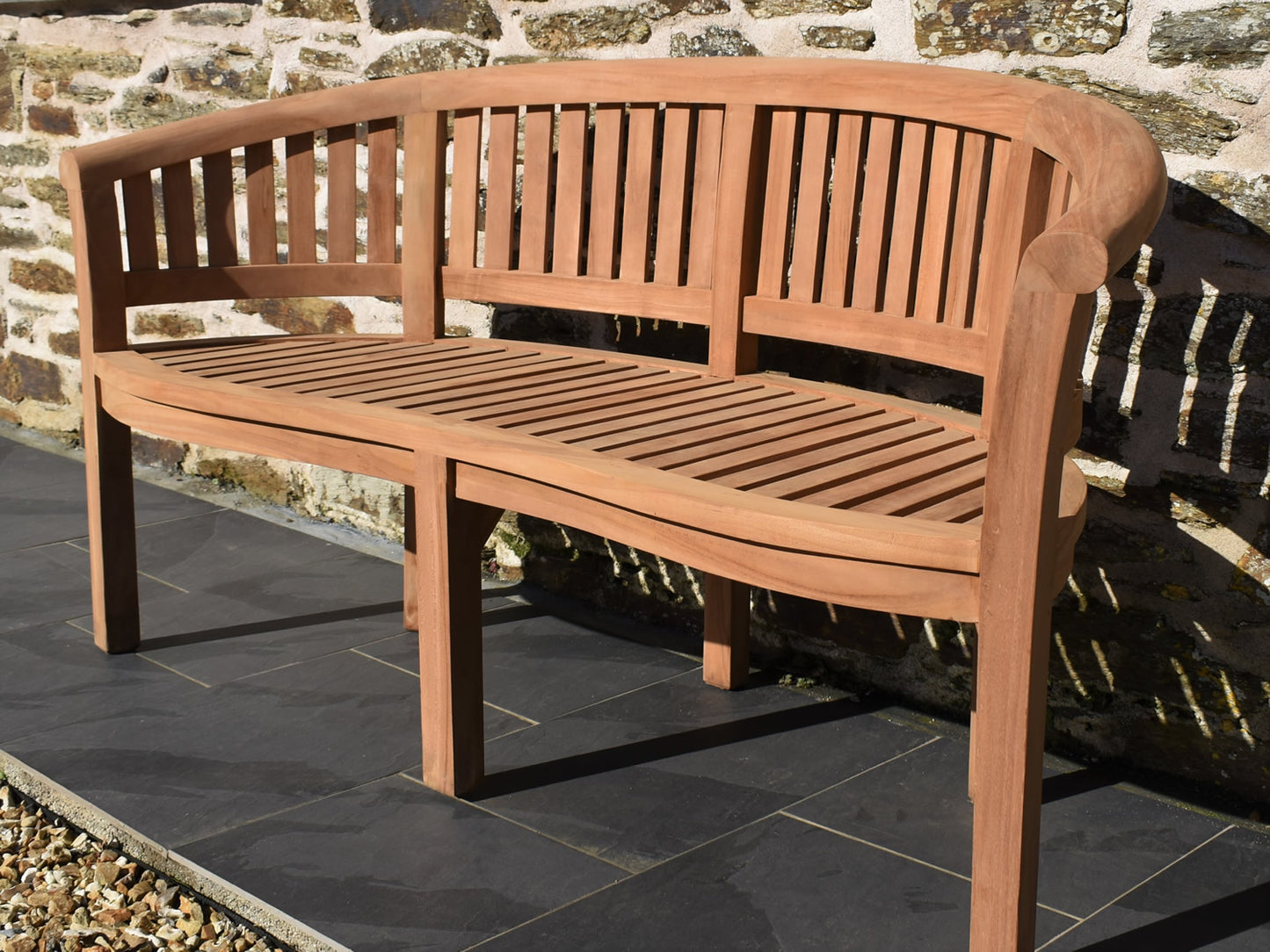 Front view of a solid teak banana bench with curved design