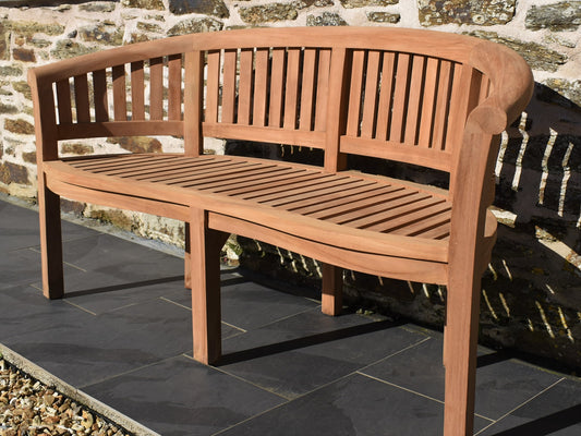 Front view of a solid teak banana bench with curved design