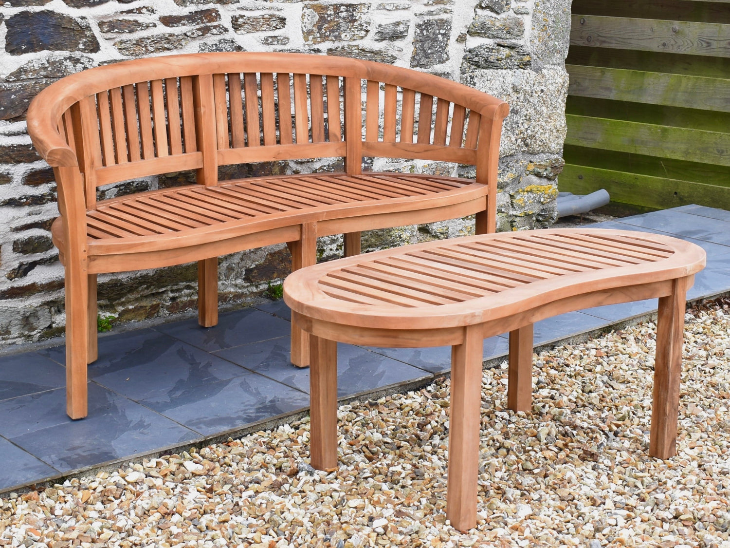Teak curved banana bench shown with matching teak garden coffee table