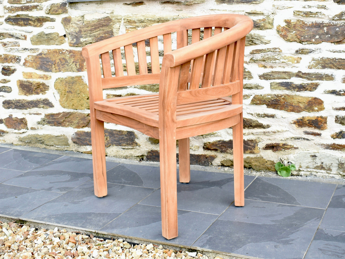 Side profile showing the half-moon curve of a solid teak garden chair