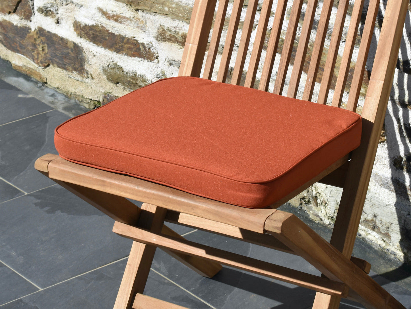 close-up polyester fabric detail for terracotta orange colour small garden seat pad cushion