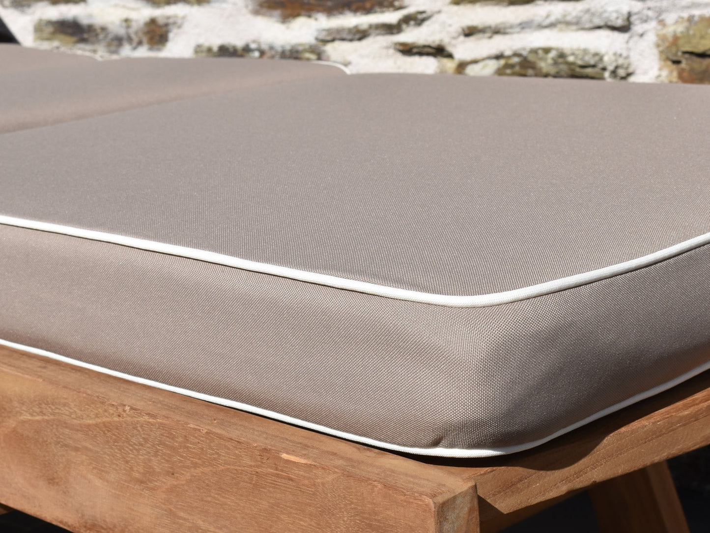 Close up detail of luxury sunlounger cushion taupe fabric with contrast white piping