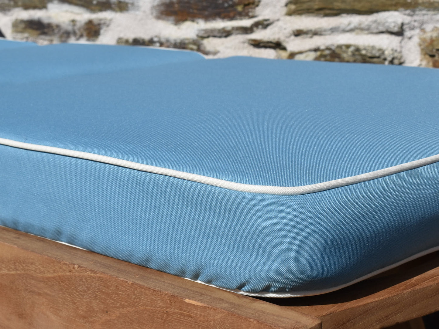close up detail of luxury light blue sunlounger cushion with contrast white piping