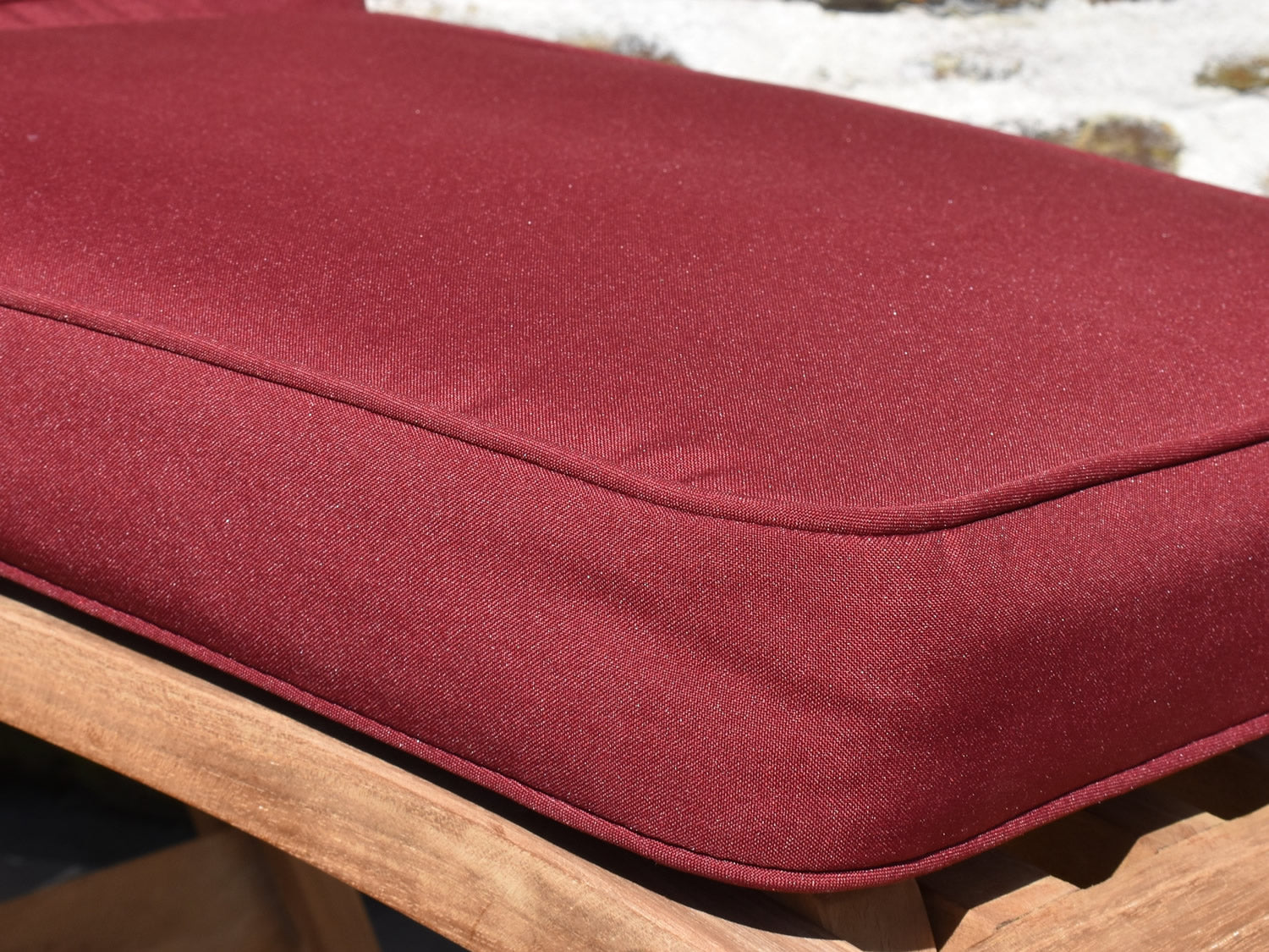 Close up fabric detail of classic steamer chair cushion in burgundy red colour