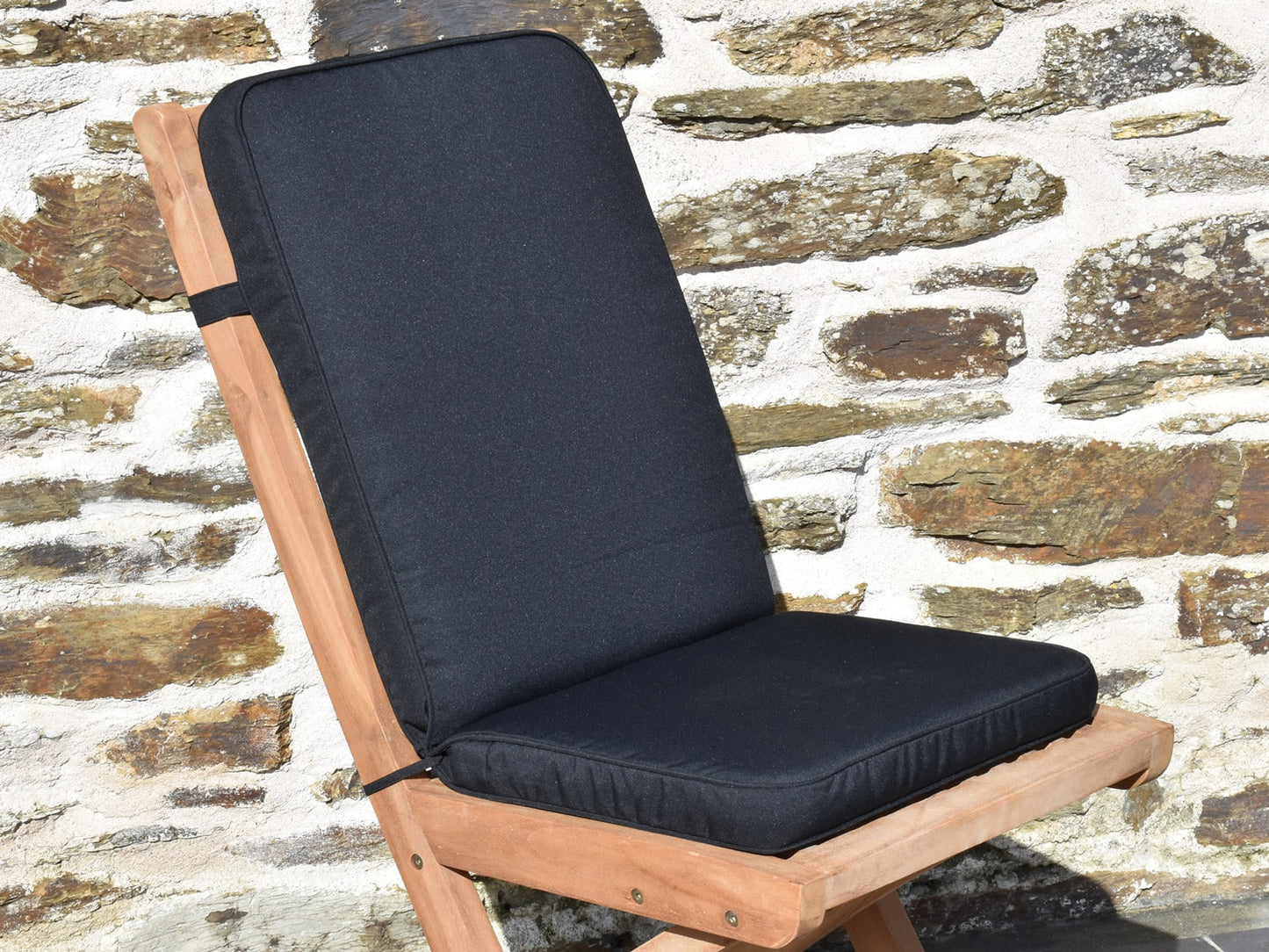 close-up of black folding pad/back garden chair cushion, finished with matching black fabric piping, ties and back strap