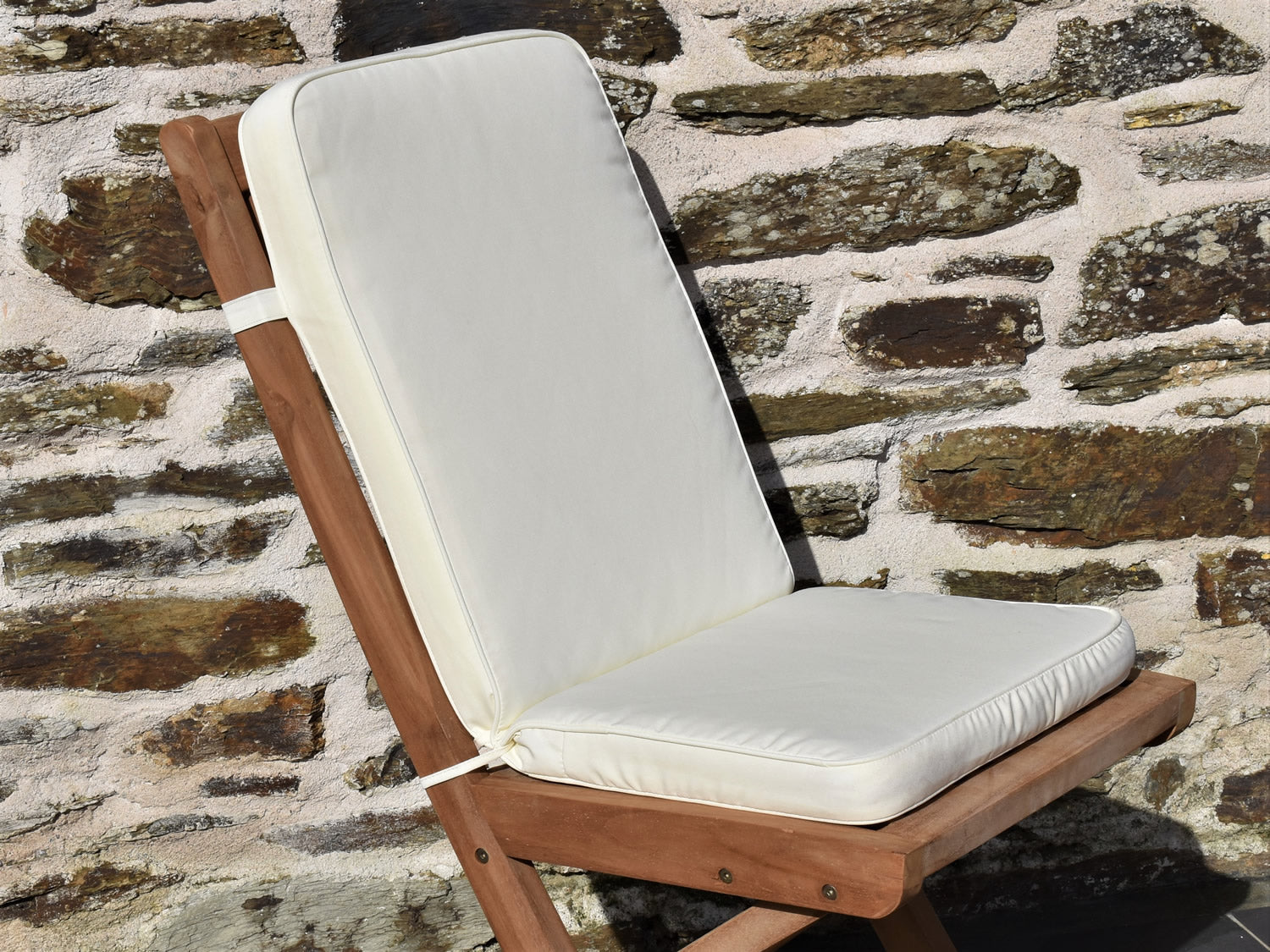 close-up natural cream colour fabric outdoor folding pad/back cushion, finished with matching fabric piping, ties and back strap