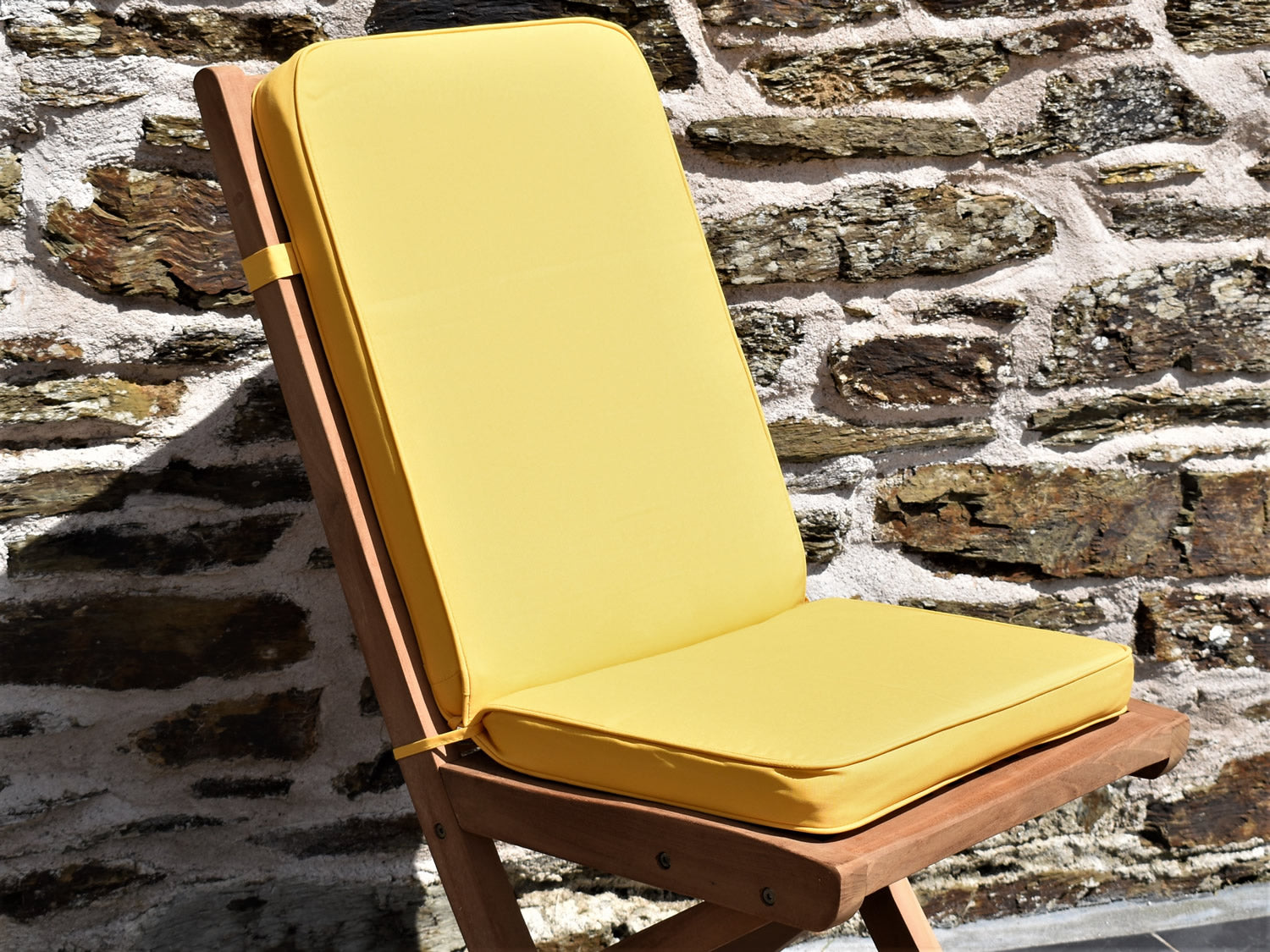 close-up detail of yellow folding seat pad and back garden chair cushion
