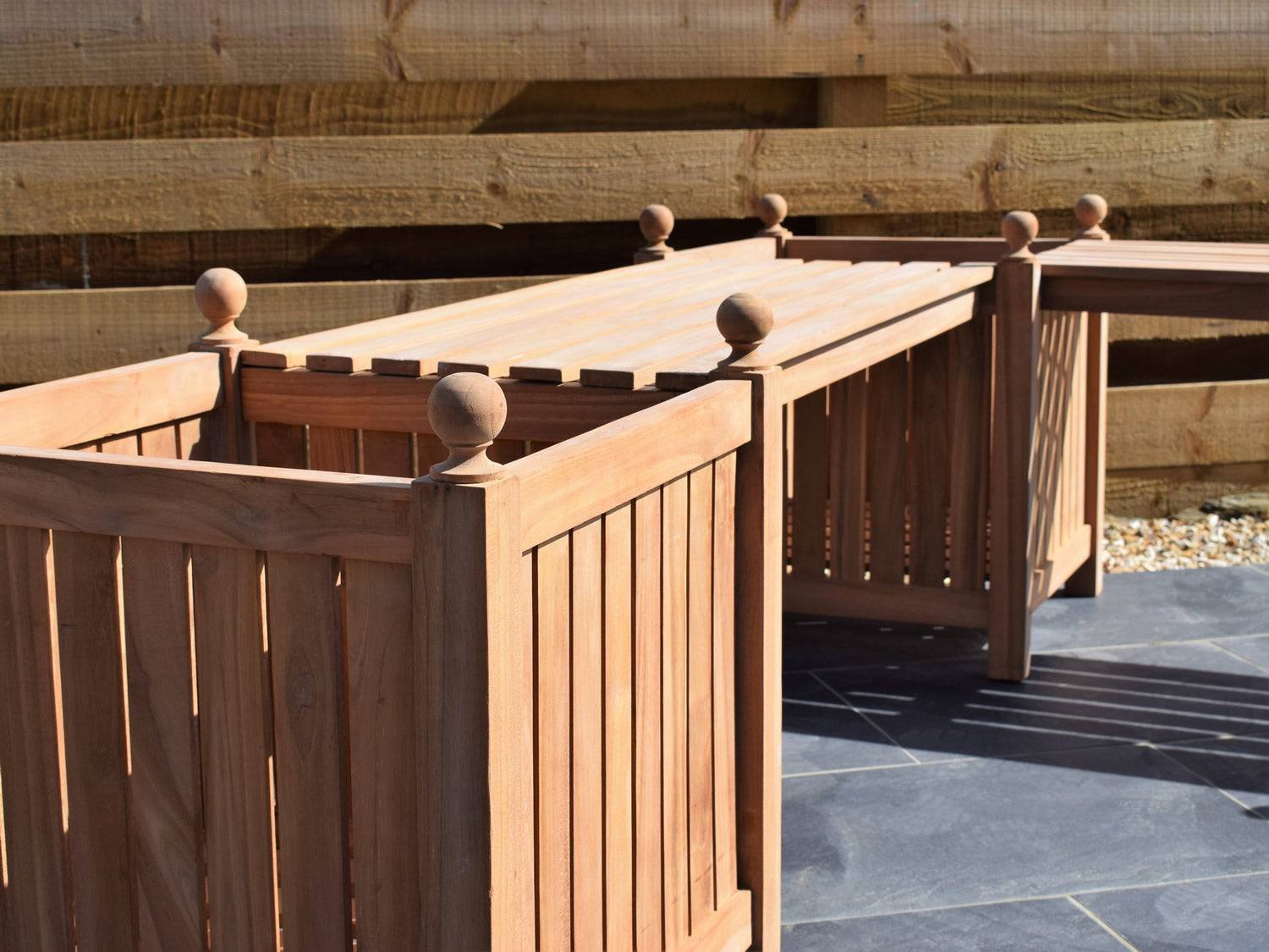 close-up detail of teak corner bench with 3 planters