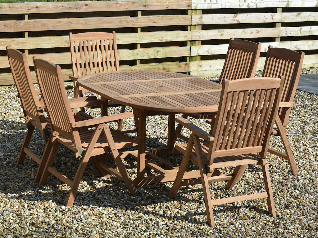 teak 120x180cm extended garden dining table shown with six folding reclining armchairs